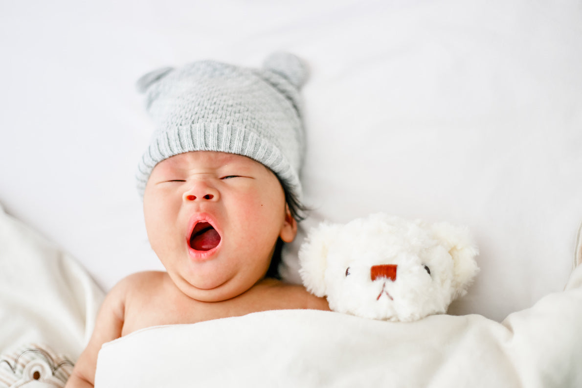 Baby Yawning In Bed With Stuffed Animal
