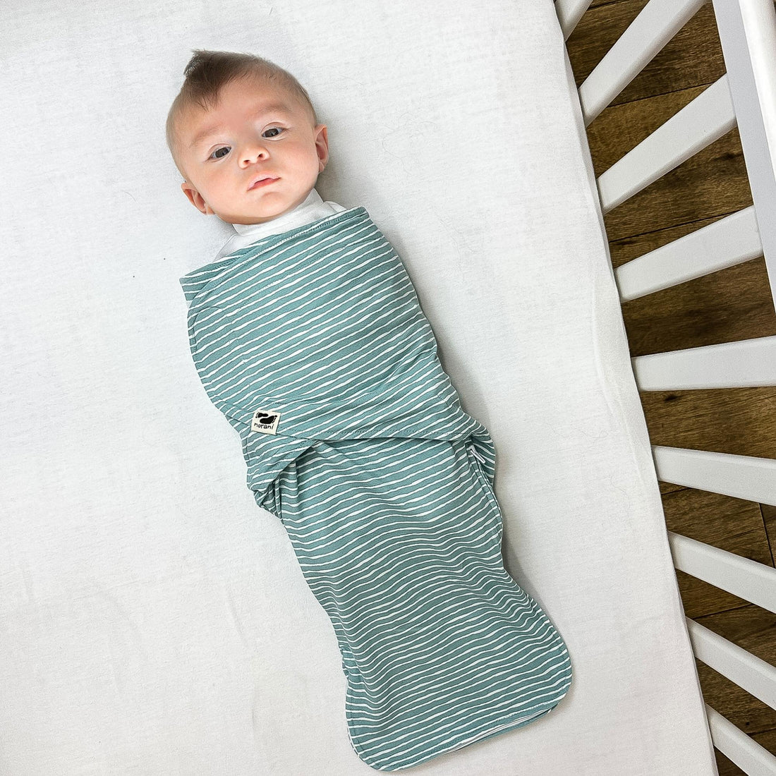 norani baby snugababe sleep pod in green and white stripes.