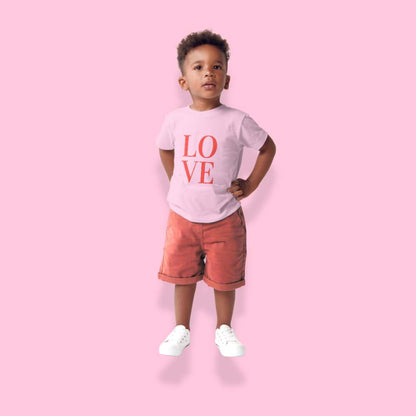 Child wearing a 'LOVE' t-shirt and red shorts on a pink background